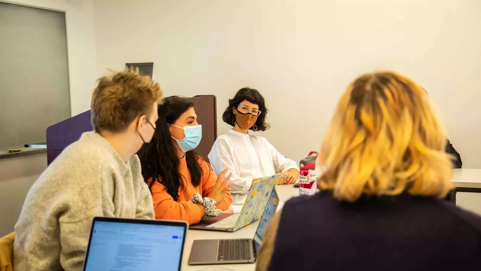 Camilla Sturm sits among students in a small classroom while she teaches